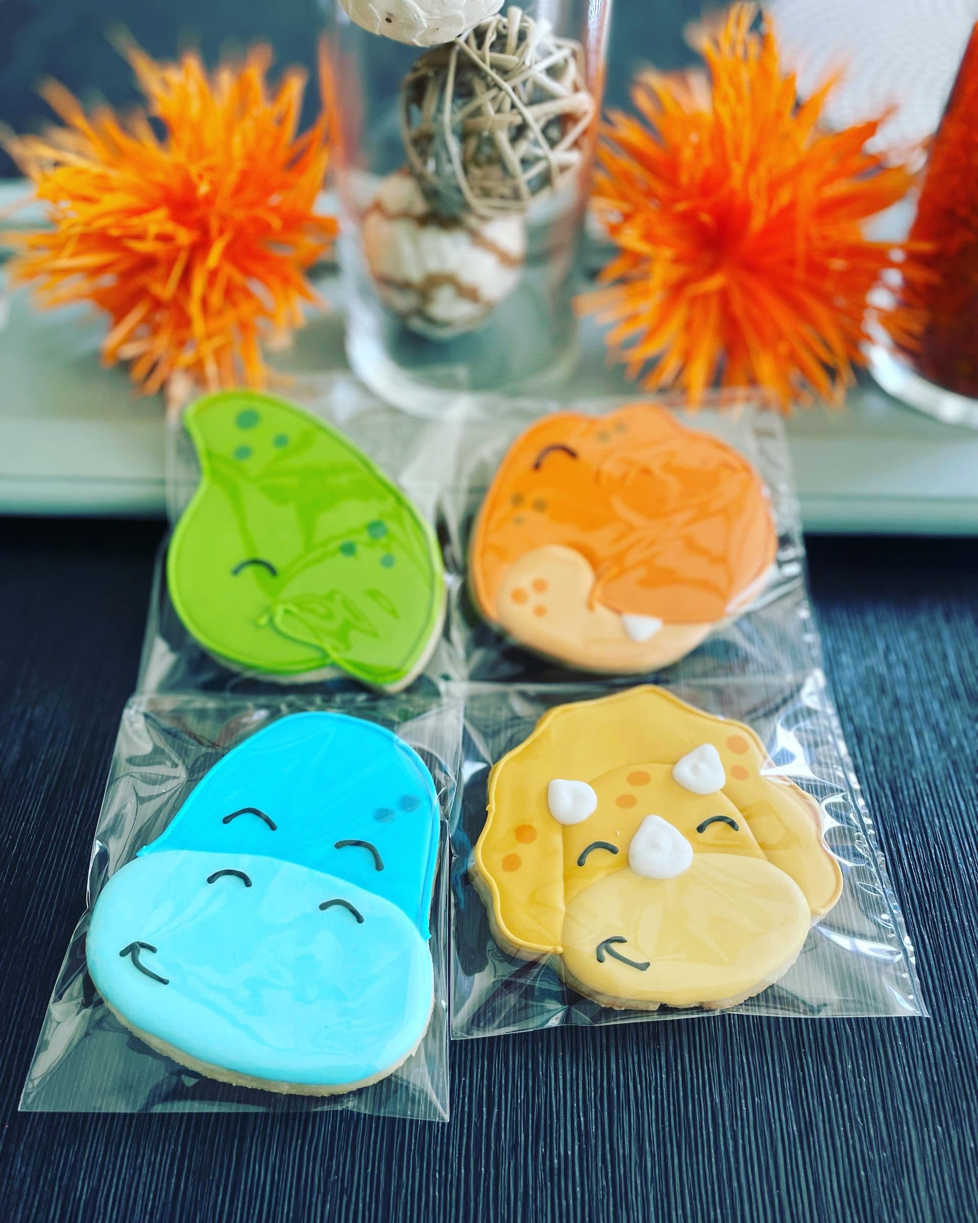 Bagged dinosaur cookies in green, orange, blue, and yellow