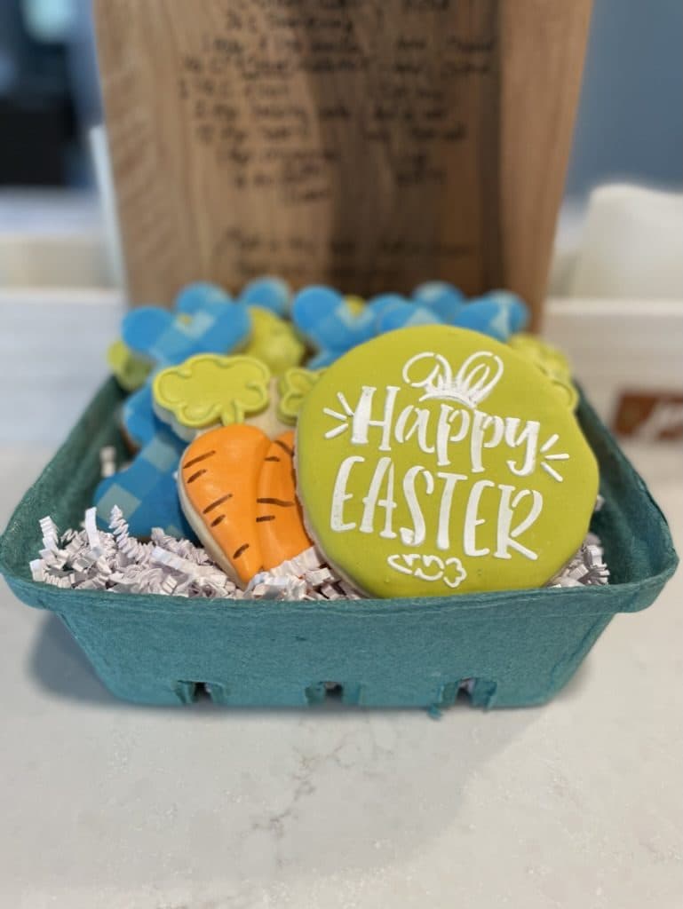 Happy Easter cookie and carrot cookie in a green berry basket