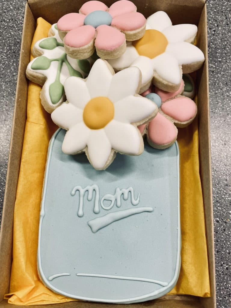 Mason jar of daisy cookies with a Mom label for Mother's Day